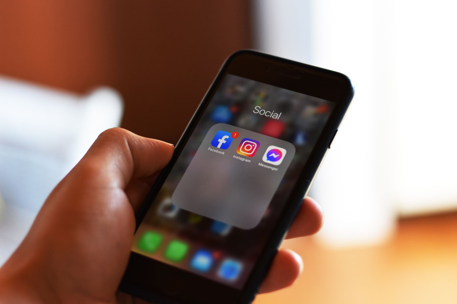Een telefoon in de hand met apps op het beginscherm