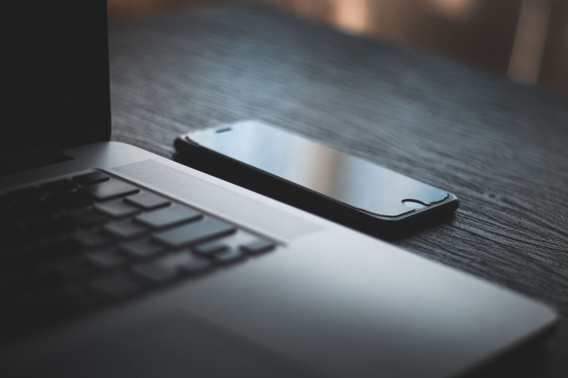 Een telefoon en laptop op tafel om foto's veilig te zetten